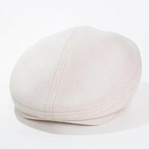 May include: A light beige newsboy cap. The hat has a rounded crown and a short, stiff brim. The cap is made of a textured fabric and features a stitched seam detail running down the center of the crown.