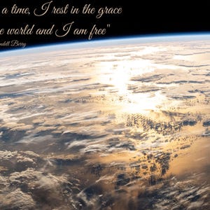 Puede incluir: Una imagen de la Tierra desde el espacio, mostrando la curvatura del planeta y la atmósfera. El sol se refleja en el océano. La cita "For a time, I rest in the grace of the world and I am free" de Wendell Berry está escrita en cursiva.