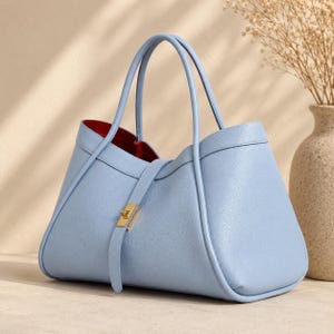 Designer inspired calf leather handbag with structured shape and refined modern fashion aesthetic.