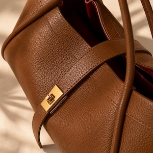 Beige genuine leather tote handbag for women with sophisticated pebbled texture and gold hardware.