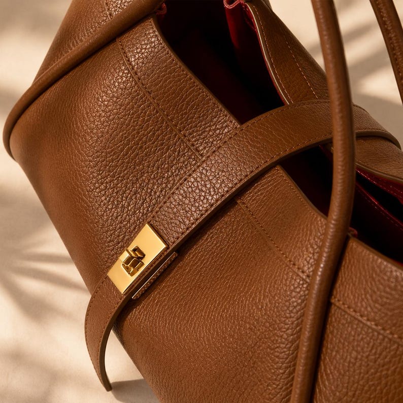 Beige genuine leather tote handbag for women with sophisticated pebbled texture and gold hardware.