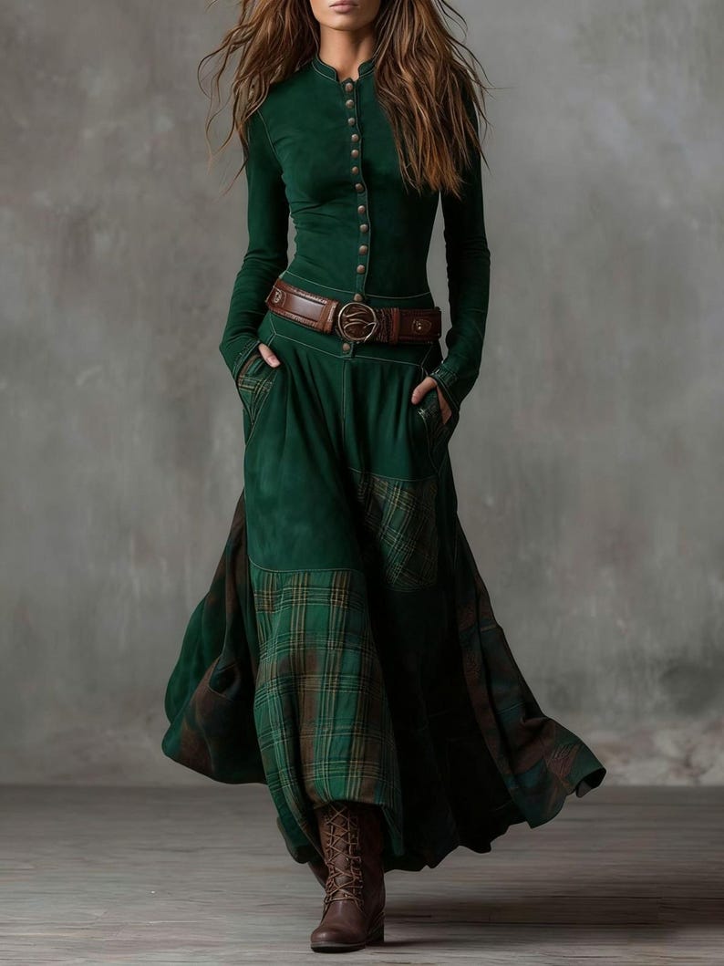 May include: A long-sleeved, emerald green dress with a high collar and button-down front. The dress features a brown leather belt and a skirt with a plaid pattern. The model is wearing brown boots.