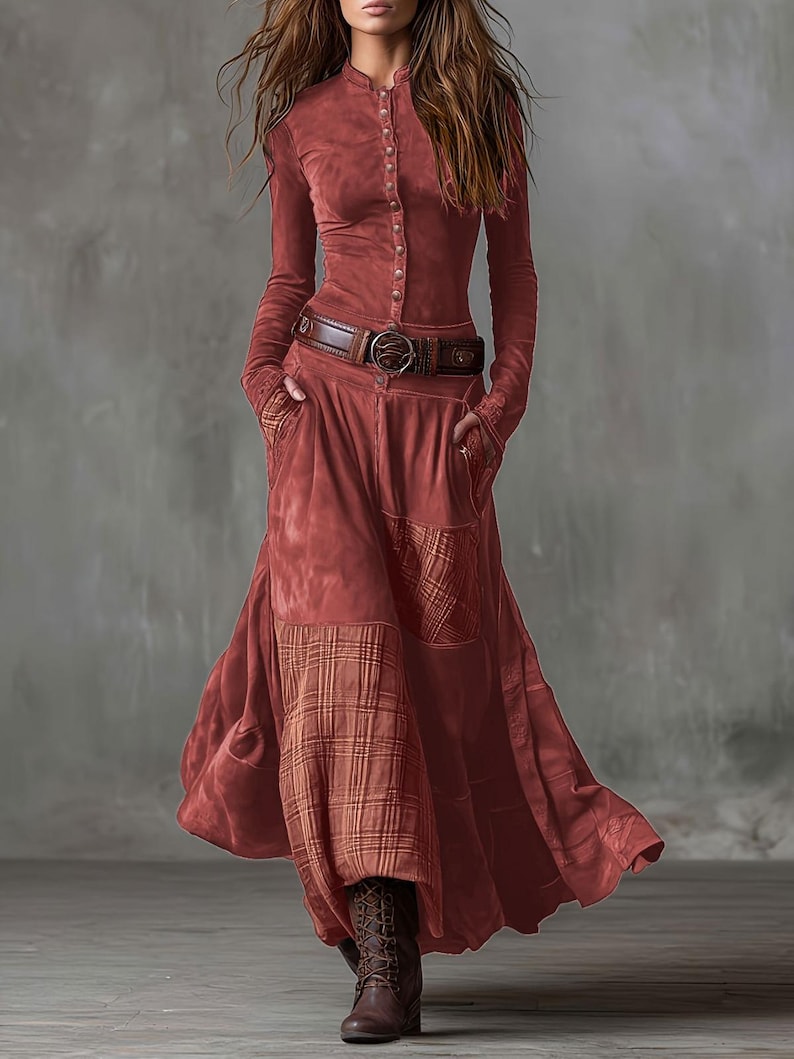 May include: A rust-colored long-sleeve dress with a button-up front, a brown belt, and a flowing skirt. The skirt features a plaid pattern on the lower portion. The dress is paired with brown boots.