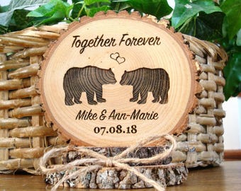 May include: A wooden slice with the text "Together Forever" and two bears facing each other. The text "Mike & Ann-Marie" and the date "07.08.18" are also engraved on the slice.