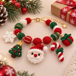 May include: A gold-tone charm bracelet featuring crocheted red, green, and white beads. The bracelet includes dangling crocheted charms shaped like a Christmas tree, a Santa Claus face, a candy cane, a gift box, and a white snowflake.