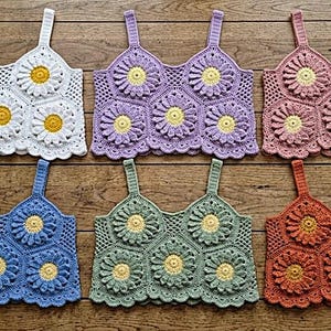 Könnte beinhalten: Sechs ärmellose Häkel-Bustiers in zwei Reihen angeordnet. Jedes Oberteil besteht aus zusammengesetzten hexagonalen Blumenmotiven mit gelben Mitten und Blütenblättern in Weiß, Lavendel, Altrosa, Blau, Salbeigrün und Terrakotta-Orange.