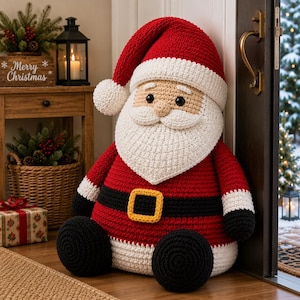 Puede incluir: Un muñeco de Papá Noel tejido a ganchillo a mano, con un gorro rojo con pompón blanco, barba blanca, abrigo rojo con cinturón negro y hebilla amarilla, y botas negras, elaborado con puntos de hilo texturizados en toda la figura.