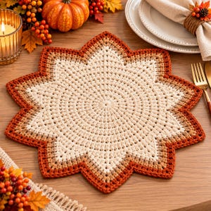 Puede incluir: Un mantel individual de ganchillo en forma de estrella con un patrón de color degradado que transita desde un centro crema a tonos marrón claro, marrón medio y un borde rojo anaranjado oscuro con diseño de puntada circular.