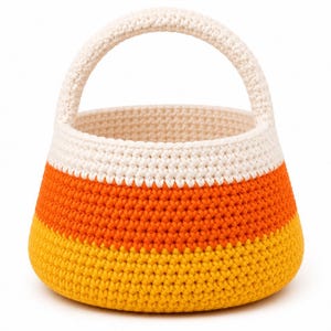 May include: A round, crocheted basket featuring a color-blocked design with horizontal stripes of yellow at the base, orange in the middle, and white at the top. The basket includes a single, thick, arched handle made of the same white crocheted yarn.