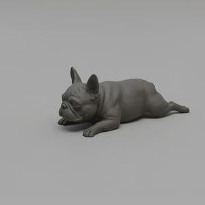 Könnte beinhalten: Eine graue Skulptur einer Französischen Bulldogge in entspannter Pose. Der Hund liegt mit ausgestreckten Vorderpfoten und erhobenem Kopf da und zeigt seine charakteristischen Merkmale. Die Skulptur steht vor einem schlichten grauen Hintergrund.