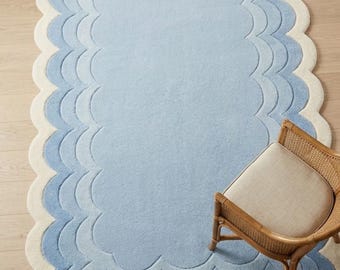 Alfombra de lana tejida a mano con borde festoneado y borde ondulado azul pastel para decoración de habitación infantil.