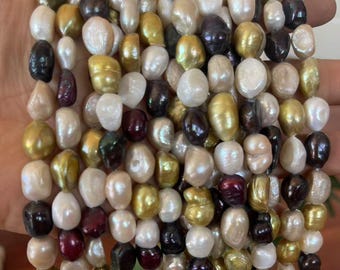 Könnte beinhalten: Eine mehrsträngige Halskette aus unregelmäßigen, barocken Süßwasserperlen in einer vielfältigen Farbpalette, darunter Weiß, Creme, Gold, Bronze, Dunkelbraun und Tiefviolett, angeordnet in mehreren vertikalen Reihen glänzender Perlen.