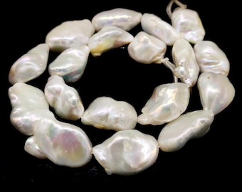 Könnte beinhalten: Eine Kette aus weißen Barockperlen. Die Perlen haben unregelmäßige Formen und eine schimmernde Oberfläche mit schillernden Farben wie Rosa, Grün und Gelb. Sie sind auf einem Faden aufgereiht und bilden ein Schmuckstück.