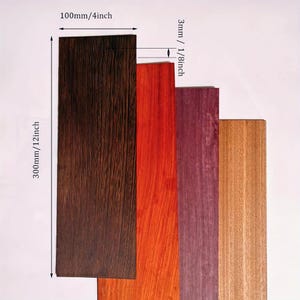 May include: A collection of four rectangular wood planks in varying colors: dark brown, red-orange, purple, and light brown. The planks are 4 inches wide, 12 inches long, and 1/8 inch thick. The wood grain is visible.