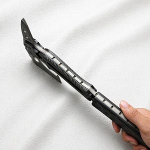May include: A black and silver tactical tomahawk axe with a sharp blade and a textured handle. The axe features a hammer head and a pointed spike, ideal for outdoor activities and survival.