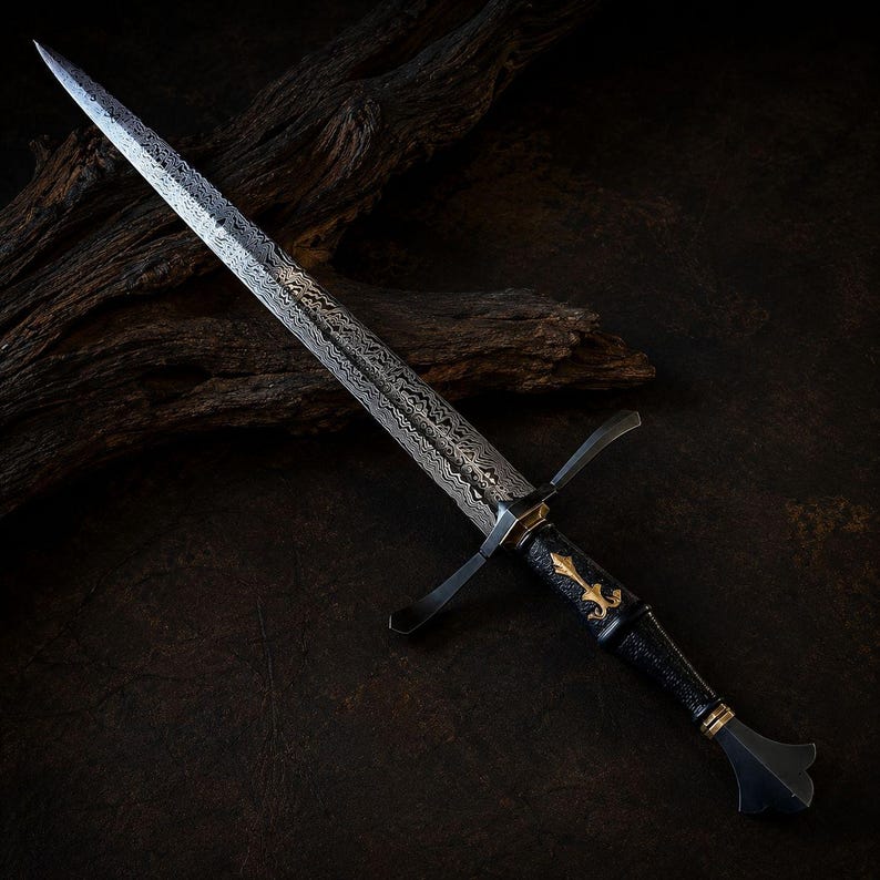 May include: A dagger with a patterned Damascus steel blade, a dark textured handle, and a gold-coloured fleur-de-lis emblem. The crossguard is dark metal, and the pommel features a flared shape with gold-coloured accents at the base of the grip.