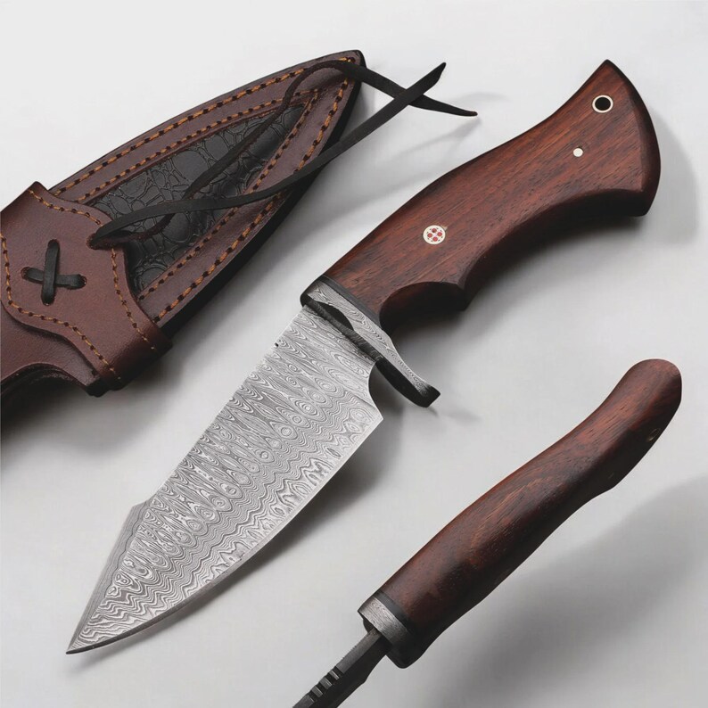 May include: A hunting knife with a patterned steel blade and a dark wood handle. The knife is accompanied by a brown leather sheath. The handle has a small decorative inlay. The blade has a unique pattern.
