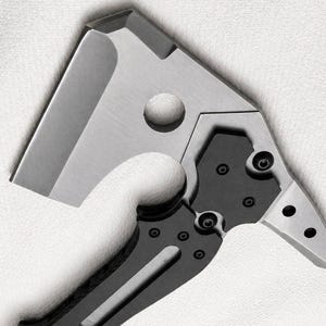 May include: Close-up of a stainless steel and black folding knife. The blade is a modified cleaver shape with a circular hole. The handle is black with silver accents and visible screws. The knife is designed for utility and everyday carry.