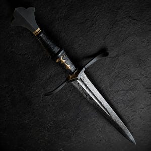 May include: A dagger featuring a patterned Damascus steel blade, a black textured grip, and a gold-coloured metal inlay. The hilt includes a black crossguard and a flared pommel, showcasing a sharp, pointed tip and intricate metalwork details.