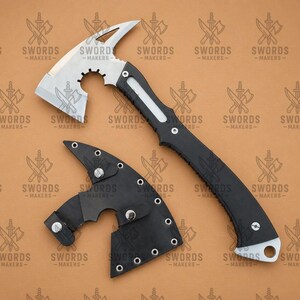 May include: A tactical axe with a silver blade and a black handle, accompanied by a black leather sheath. The axe features a hammer head and a curved blade. The text "SWORDS -MAKERS-" is visible on the background.