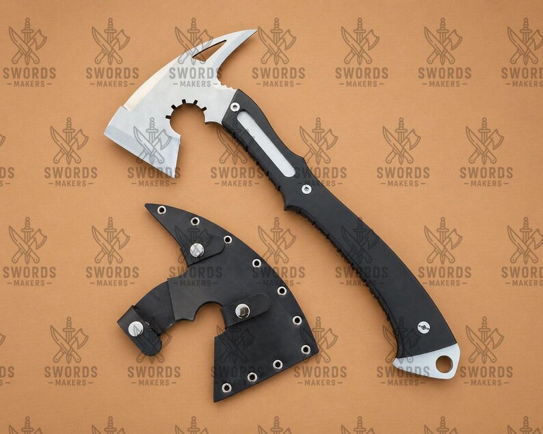 May include: A tactical axe with a silver blade and a black handle, accompanied by a black leather sheath. The axe features a hammer head and a curved blade. The text "SWORDS -MAKERS-" is visible on the background.