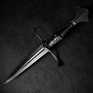 May include: A dagger featuring a patterned Damascus steel blade with a sharp point. The handle is black with a textured grip, accented by a gold-coloured inlay and a flared pommel. A black metal crossguard with curved quillons extends from the hilt.