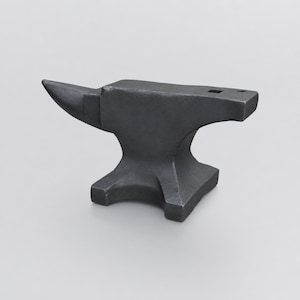 May include: A solid dark gray metal anvil featuring a pointed horn on the left side, a flat top surface with a square hardy hole, and a circular pritchel hole on the right side. The base is wide and stable with four feet supporting the heavy body.