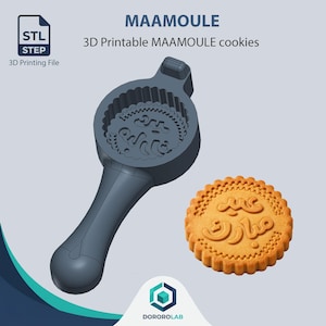 Peut inclure: Un moule à biscuits gris foncé imprimable en 3D avec une poignée et une tête circulaire présentant un motif complexe en écriture arabe, accompagné d'un biscuit rond doré avec le même texte arabe en relief Eid Mubarak.