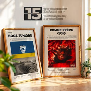 May include: Two framed posters leaning against a wall. One features the text "BOCA JUNIORS" with a blue and yellow flag design and stadium imagery. The other poster says "COMME PR&Eacute;VU NINHO" with a red and black image. The wall has text that says "15 % off when you buy 2 or more items".