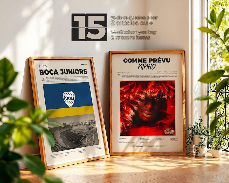 May include: Two framed posters leaning against a wall. One features the text "BOCA JUNIORS" with a blue and yellow flag design and stadium imagery. The other poster says "COMME PR&Eacute;VU NINHO" with a red and black image. The wall has text that says "15 % off when you buy 2 or more items".