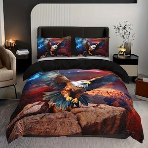 Könnte beinhalten: Bettwäsche-Set mit einem Adler-Design, bestehend aus einem Bettbezug und zwei Kissenbezügen. Die Adler-Illustration hat einen Canyon- und Sternenhimmel-Hintergrund. Das obere Laken ist schwarz.