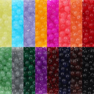 May include: A selection of vibrant, round beads in a spectrum of colours: yellow, blue, purple, orange, pink, red, green, grey, dark green, purple, dark red, dark blue, and black. The beads are arranged in vertical columns.