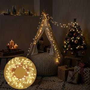 Op de afbeelding: Een gezellige kerstscène met een kleine versierde boom, een tipi-tent versierd met lichtslingers en een gloeiende krans. De kamer is zwak verlicht, met kaarsen en ingepakte cadeaus die bijdragen aan de feestelijke sfeer.