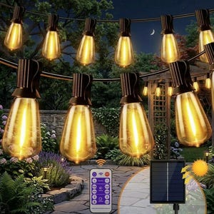 Könnte beinhalten: Lichterkette für den Außenbereich mit warmgelben Glühbirnen. Die Glühbirnen im Vintage-Edison-Stil hängen in einem Garten. Das Bild zeigt eine Fernbedienung und ein Solarpanel. Der Hintergrund umfasst Grün, eine Steinmauer und einen Nachthimmel mit Mond.