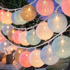 以下が含まれることがあります： ピンク、ブルー、ゴールドの色合いのカラフルなグローブライトのストリング。ライトは白いワイヤーに繋がれており、お祝いの装飾的な雰囲気を醸し出しています。 屋内または屋外での使用に最適です。