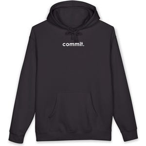 Op de afbeelding: Een zwarte hoodie met een capuchon met trekkoord en een voorzak. Het woord "commit." staat in het wit op de borst gedrukt. De hoodie is gemaakt van een zacht materiaal.