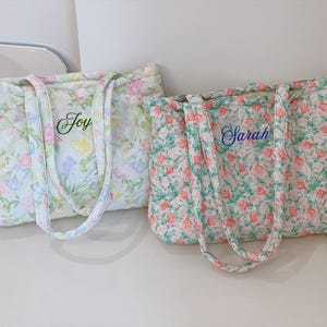 Pu&ograve; includere: Due borse tote floreali trapuntate. Una borsa &egrave; verde chiaro con il nome "Joy" ricamato in verde. L'altra borsa &egrave; floreale con il nome "Sarah" ricamato in blu. Entrambe le borse hanno manici abbinati.