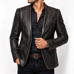 May include: A dark brown distressed leather blazer featuring a notched lapel, two front buttons, and two flap pockets. The jacket is worn over a black button-down shirt with a brown leather belt and black trousers, creating a structured look.