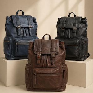 May include: Three backpacks in blue, brown, and black, each featuring a top flap with two buckle straps, a drawstring closure, a front zippered pocket, and two side zippered pockets. Each bag has a top handle and a logo embossed on the flap.