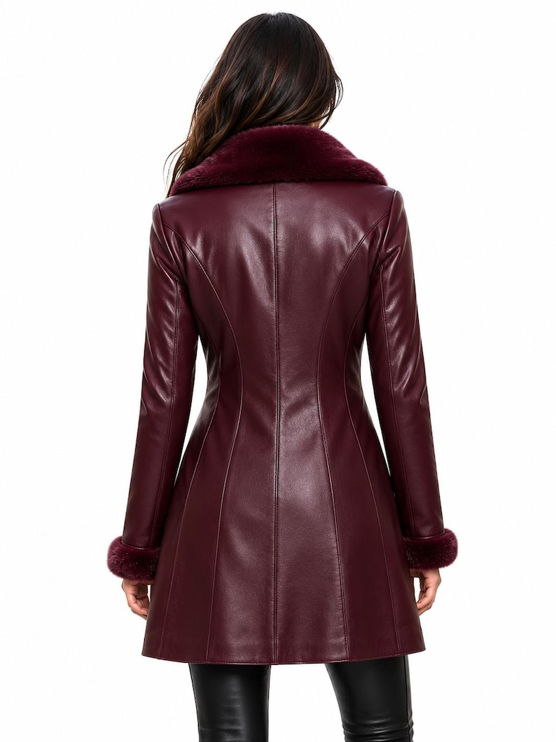 May include: A burgundy long-sleeved coat made of a smooth material, featuring a wide faux fur collar in a matching deep red tone and matching faux fur trim at the cuffs. The coat has a fitted bodice with vertical seam detailing.