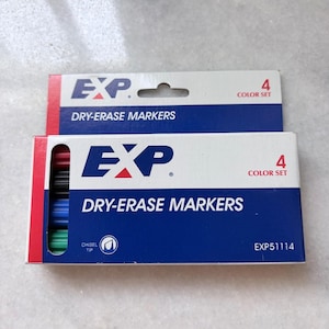 Peut inclure: Deux paquets de marqueurs effaçables à sec EXP. Chaque paquet est blanc avec un panneau bleu et des accents rouges. Les paquets affichent le logo EXP, les mots "DRY-ERASE MARKERS" et "4 COLOR SET". Un paquet montre les marqueurs à pointe biseautée.