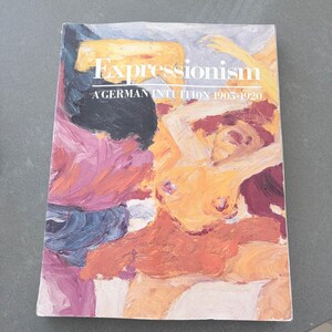 Może przedstawiać: Książka zatytułowana "Expressionism A German Intuition 1905-1920" zawiera na okładce kolorowy abstrakcyjny obraz. Grafika przedstawia nagie postacie w odcieniach pomarańczu, różu i błękitu, z białym tytułem.