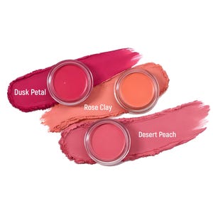 May include: Three makeup pots with swatches of color. The colors are Dusk Petal, Rose Clay, and Desert Peach. The Dusk Petal swatch is a deep pink, Rose Clay is a light peach, and Desert Peach is a medium pink.