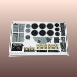Könnte beinhalten: Ein individuelles Aufkleberblatt mit verschiedenen detaillierten Raumschiff-Bedienfeld-Designs in Grau-, Beige- und Schwarztönen. Das Blatt enthält kreisförmige und rechteckige Elemente mit dem Text "CUSTOM STICKER SHEET" am unteren Rand.