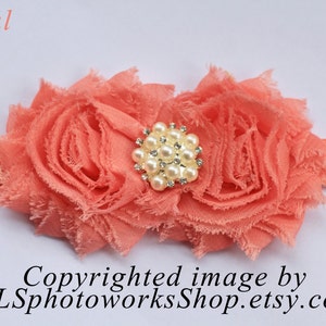 May include: Coral colored fabric flower headband with a pearl and rhinestone embellishment.