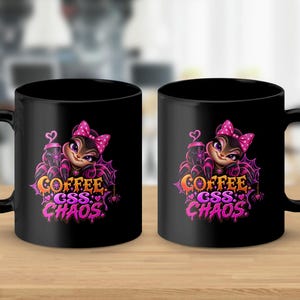 May include: Two black ceramic mugs featuring a graphic of a stylized spider character with a pink polka dot bow, holding a coffee cup. The design includes a spider web and the text "COFFEE CSS CHAOS" in a dripping, vibrant pink and orange font.