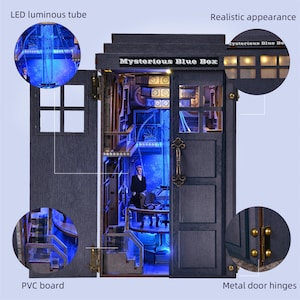 May include: A miniature blue box with the text "Mysterious Blue Box" on top. The box has an open door revealing a detailed interior with a figure, illuminated by blue LED lights. The box is made of PVC board and has metal door hinges.