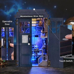 May include: A blue wooden model of a box with the text "Mysterious Blue Box". The model has an openable door, interior lights, and a touch switch. The interior features miniature furniture and details. The model is a detailed craft project.