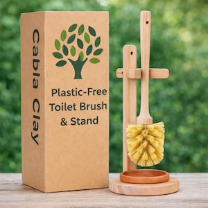 May include: A wooden toilet brush and stand set. The brush has a light-colored wooden handle and yellow bristles. The stand is made of wood and includes a small dish. The box reads "Cabla Clay" and "Plastic-Free Toilet Brush & Stand."