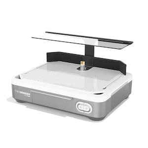 May include: A gray and white glass grinder with a black support structure and a clear light. The text "THE GRINDER" is visible on the side. The grinder has a white mesh surface and two buttons on the front.